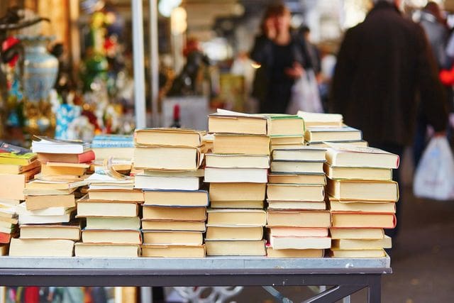 A table topped with lots of books on top of it.