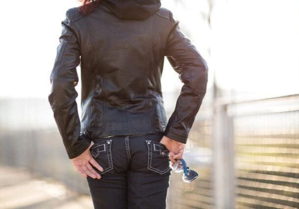 A woman in black jacket holding a water bottle.